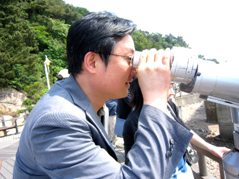 망원경으로 먼 곳을 보고있는 직원