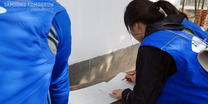 벽화 스케치를 하는 자원봉사자