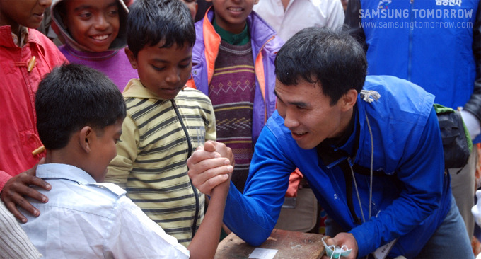 방글라데시 아이와 팔씨름하는 최용배 대리