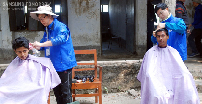 이발을 해주는 자원봉사자들