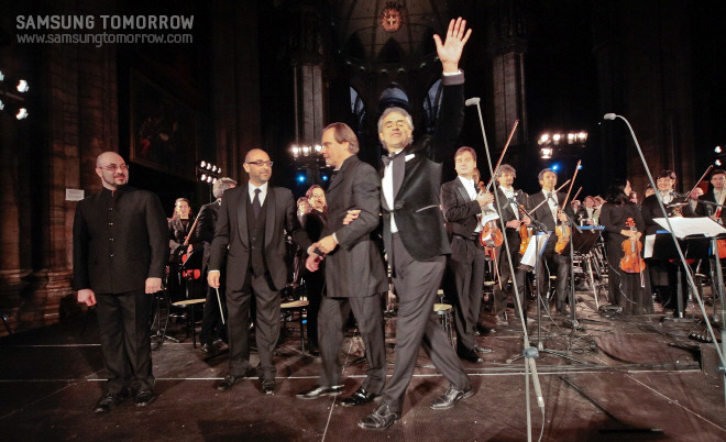 지휘자와 팔짱을 끼고 나가는 안드레아 보첼리