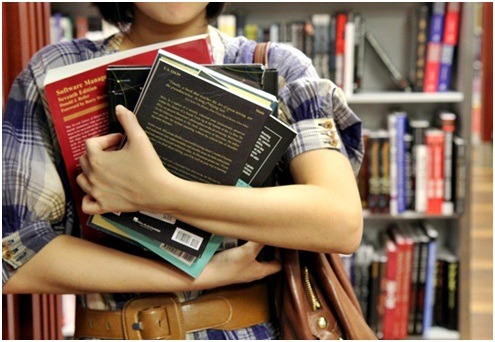 여러 권의 책을 들고 있는 여성