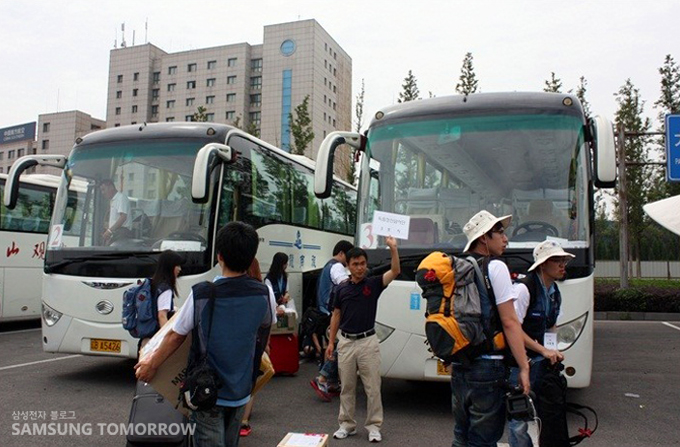 버스앞에서 플랜카드를 들고 있는 조선족 가이드 