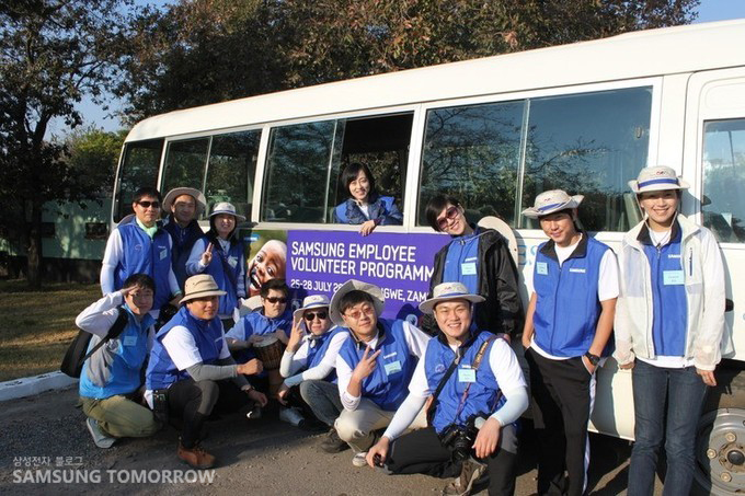 버스 앞에 있는 봉사단