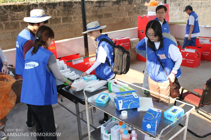 의료품을 배치해 두는 자원봉사자들