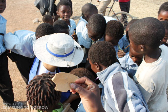 종이를 들고 몰려든 아이들
