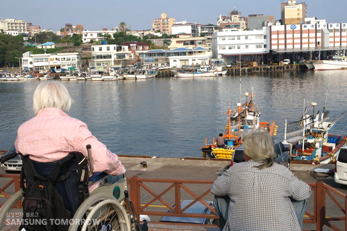 앉아서 항구를 바라보는 할머니들