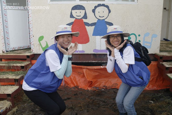 벽화앞에서 꽃받침한 자원봉사자들