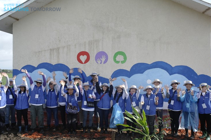 벽화 앞에서 자원봉사자들 