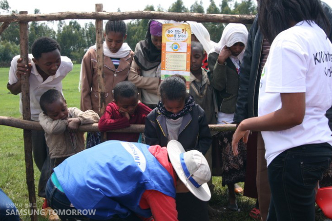 환자의 키와 몸무게를 재는 자원봉사자