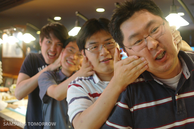 서로 장난치며 볼을 누르는 직원들