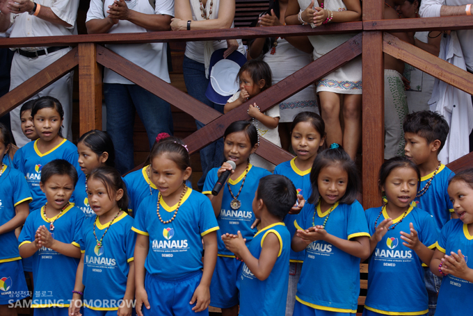 축하노래를 부르는 레스 우니도스(Tres Unidos)와 인근 마을 학생들