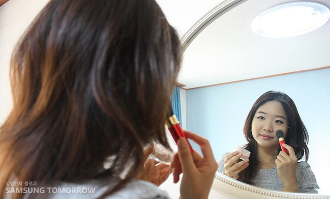 거울 앞에서 화장하는 여자