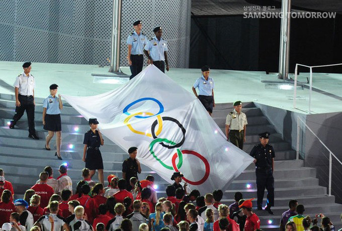 개최식 행사로 오륜기를 들고 계단을 내려가는 사람들