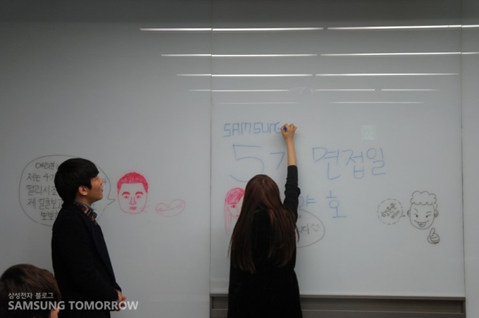 4기들이 5기를 위해 칠판에 글을 쓰고 있다.