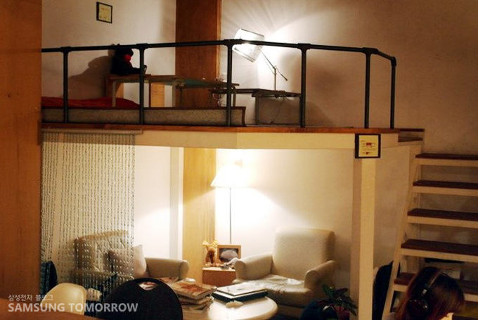 복층 집 이층에 앉아있는 사람