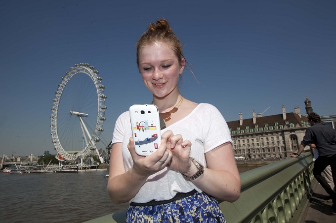 런던 아이를 등지고 런던올림픽 스페셜에디션 플립커버를 씌운 갤럭시s3를 쓰고 있는 여성