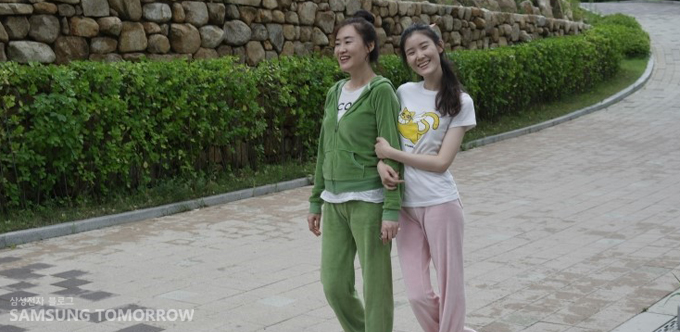 팔짱을 끼고 걷는 스토리텔러와 어머니