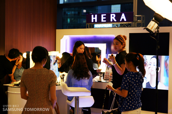 헤라 부스에서 메이크업을 받는 사람들
