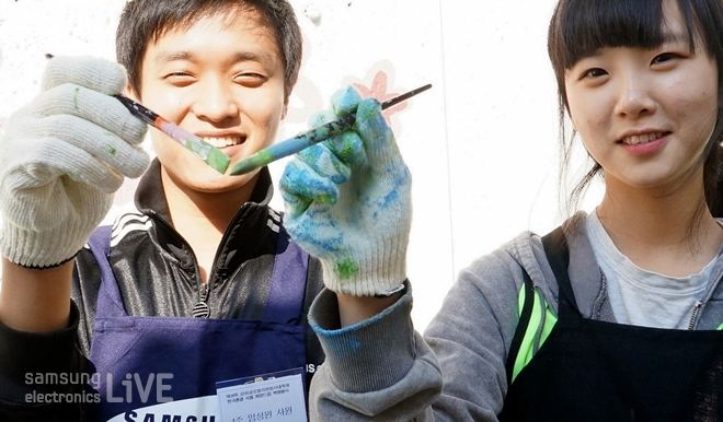 붓을 맞대고 있는 자원봉사자들