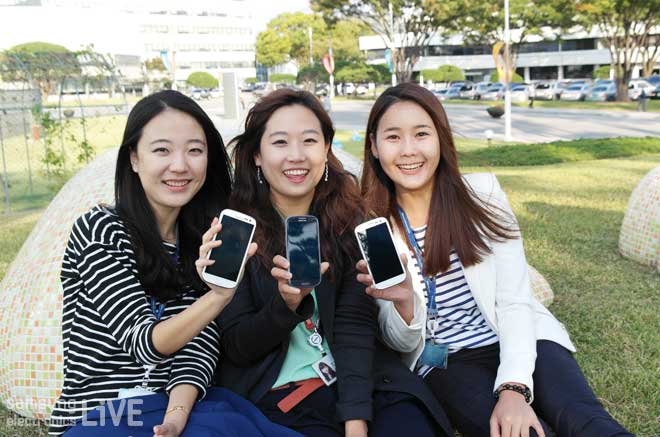 스마트 폰을 들고 있는 세 여성