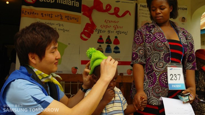 모자를 씌워주는 자원봉사자