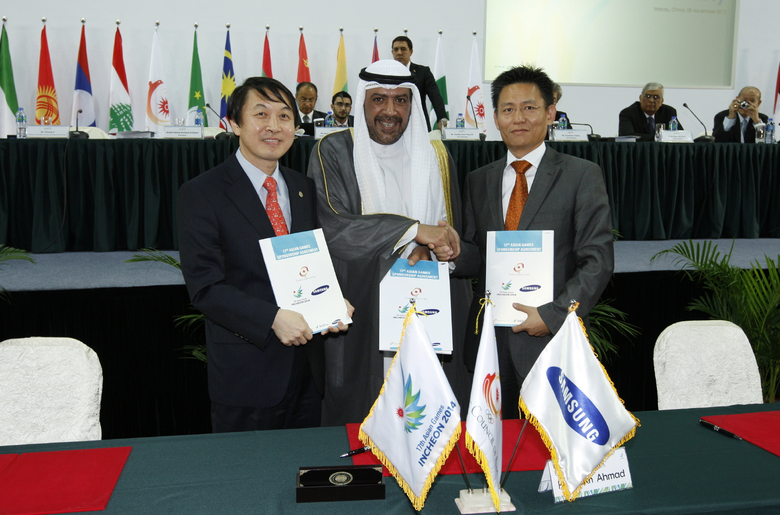 서로 악수하는 셰이크 아마드 알파하드 알사바와 권경상 인천아시안게임 조직위원회 사무총장, 황성수 삼성전자 상무