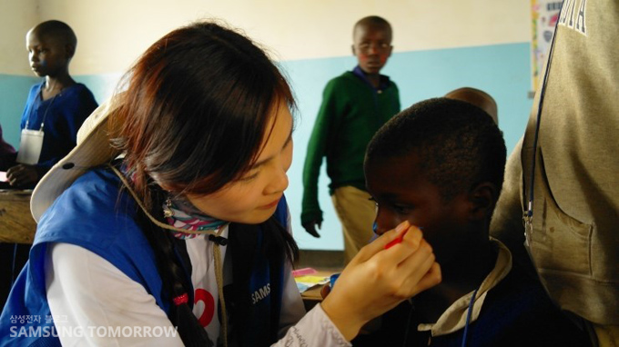 자원봉사단이 페이스 페인팅을 해주고 있다