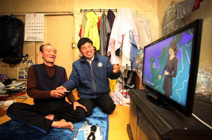 티비를 보는 할아버지와 기술자
