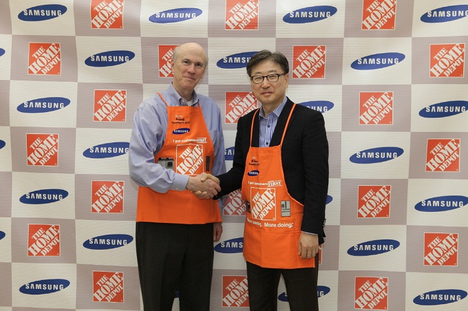 생활가전 사업부장 윤부근 사장과 홈데포의 프랭크 블레이크(Frank Blake, THD Chairman & CEO)회장이 포토존에서 악수를 하고 있다