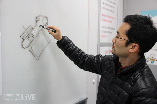 칠판에 카메라 그림을 그리는 김인식 책임