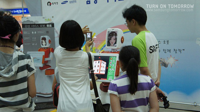 퓨로로봇을 구경하는 사람들