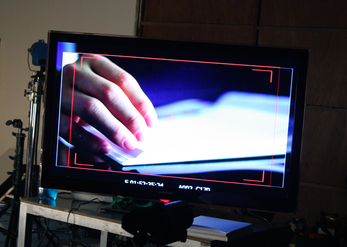 광고 모니터링 화면 책장을 넘기는 손