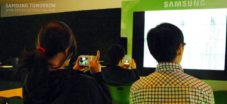 행사에 참석한 사람들이 NX100을 만지며 강의를 듣는 모습