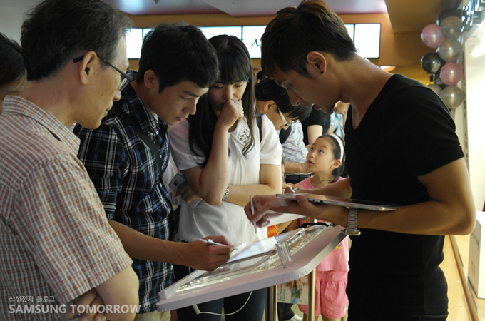 갤럭시 노트를 체험하고 있는 사람들