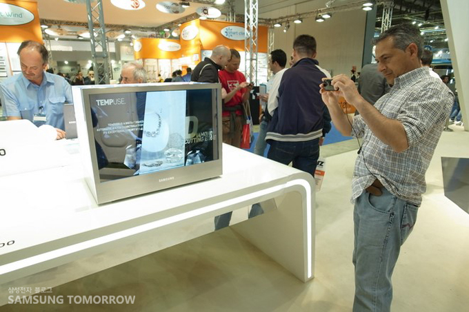 투명디스플레이를 사진찍는 남성