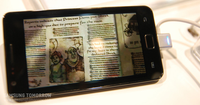 갤럭시S2로 신문을 보는 이미지