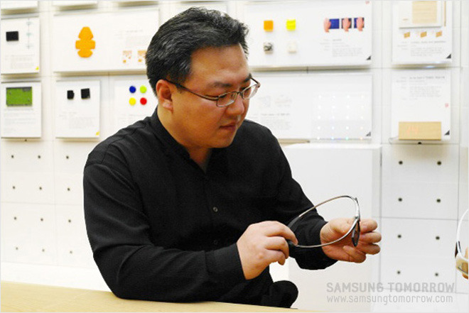 안경을 들고 설명하고 있는 3D 안경 디자이너