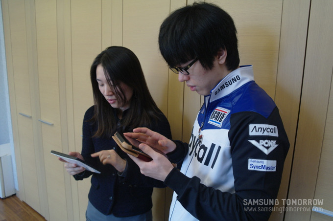 갤럭시 탭을 만지고 있는 선수들