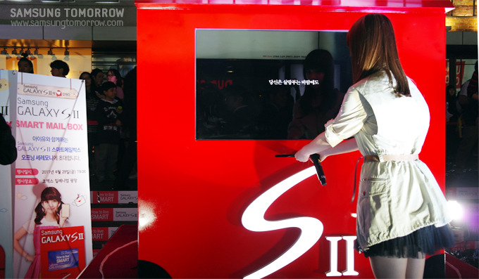 스마트 메일 박스에 엽서를 넣고 있는 아이유