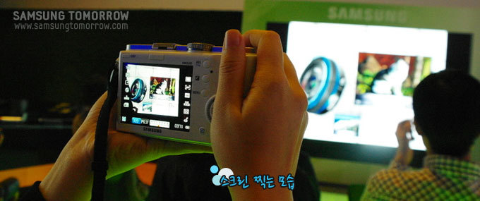 NX100으로 사진을 찍는 모습