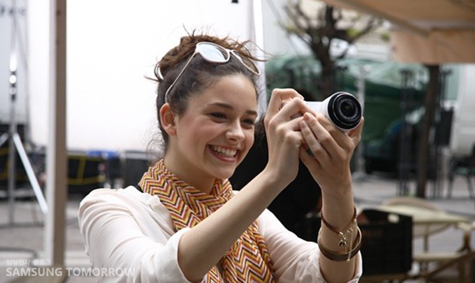 NX 카메라로 사진을 찍는 여성