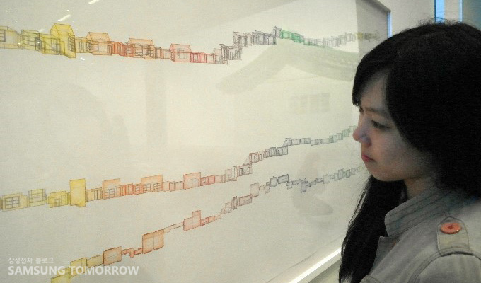 수많은 집이 나열 된 그림을 바라보는 스토리텔러