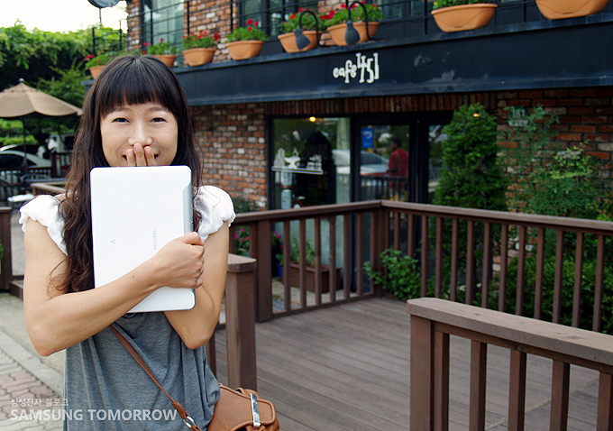 갤럭시탭을 들고 웃고 있는 여성