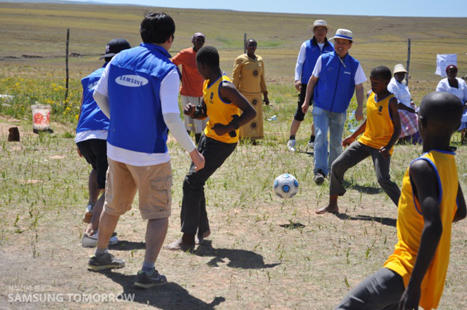 축구하는 삼성전자 직원들과 아이들