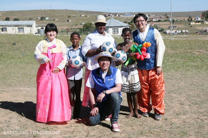 전통의상을 입고 아이들과 교육기자재를 즐기는 사람들