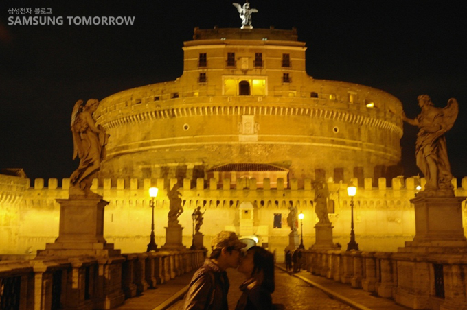 숙소에서 알게 된 신혼부부가 천사의 성앞에서 키스 하는 사진