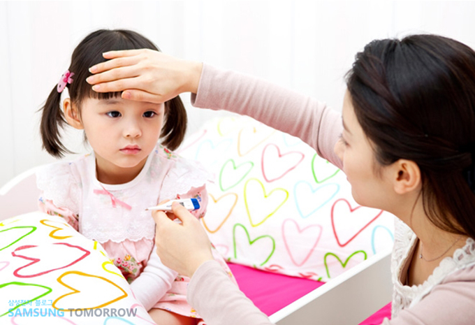 아이가 아파 열을 재고 있는 모습