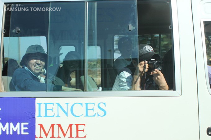 이동버스 안에서 사진을 찍는 사람들