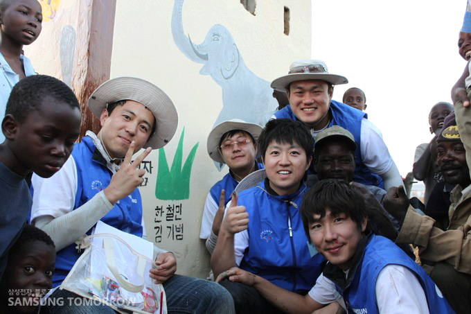 완공된 화장실 앞에서 좋아하는 봉사팀